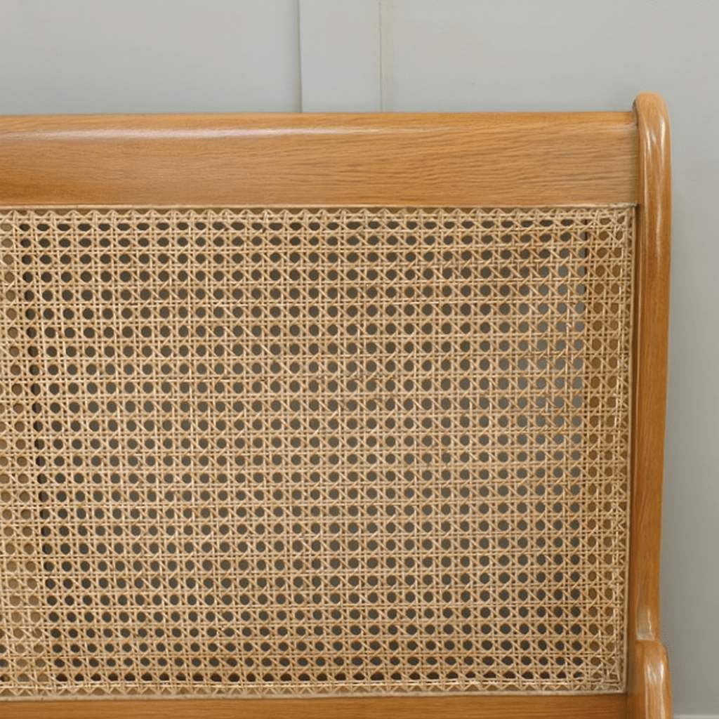 Wooden headboard with wicker panel against a gray wall