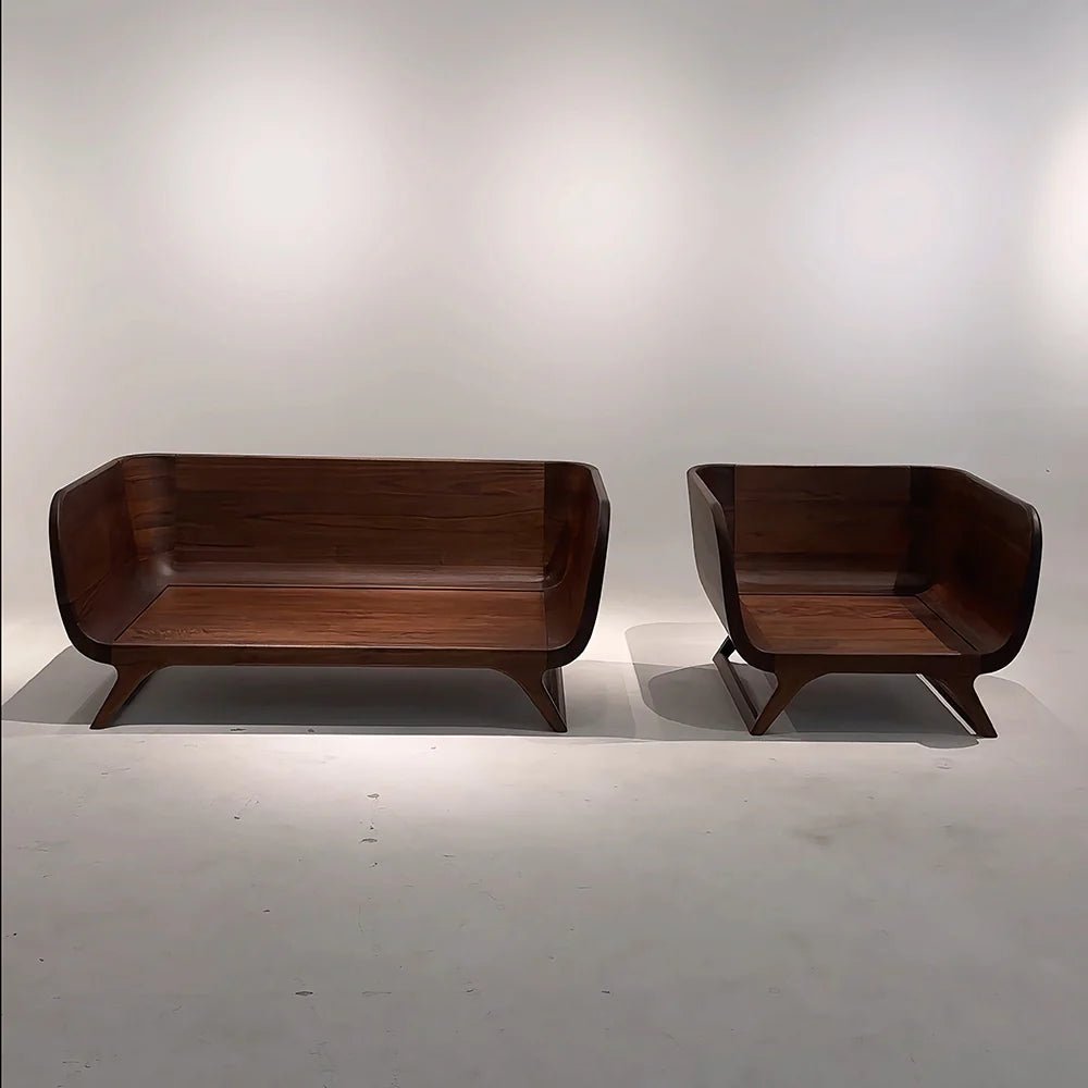 Wooden sofa and chair set against a plain white wall.