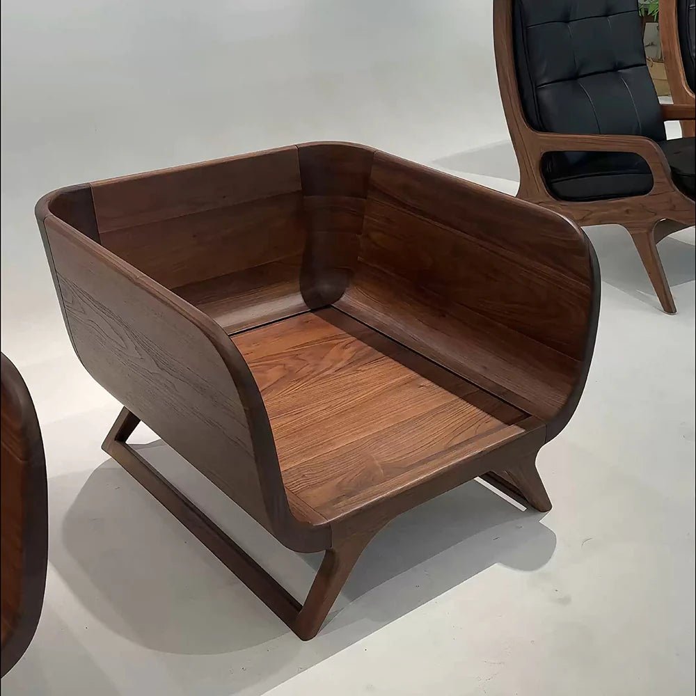 Wooden armchair with a black cushion on a white background