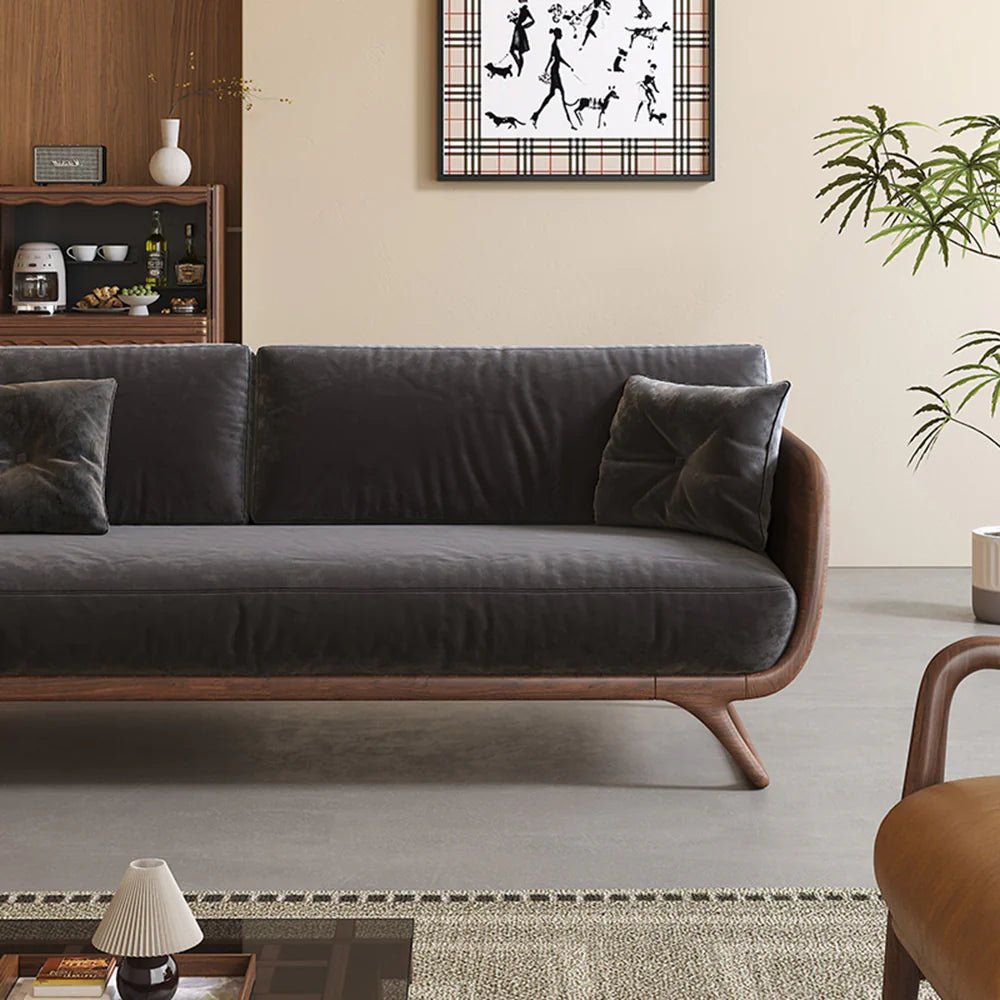 Gray sofa in a living room setting with a plant and decorative items.