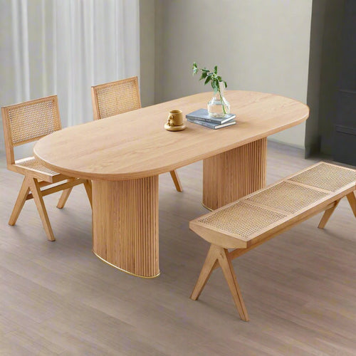 Wooden dining table with chairs and a bench in a bright room.
