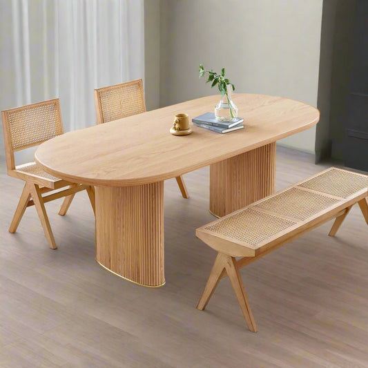 Wooden dining table with chairs and a bench in a bright room.