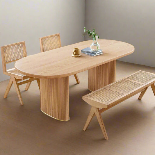 Wooden dining table with chairs and a bench in a bright room.