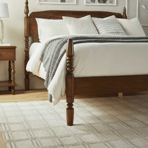 Close-up of turned pillars and dark teak wood grain on solid wood bed