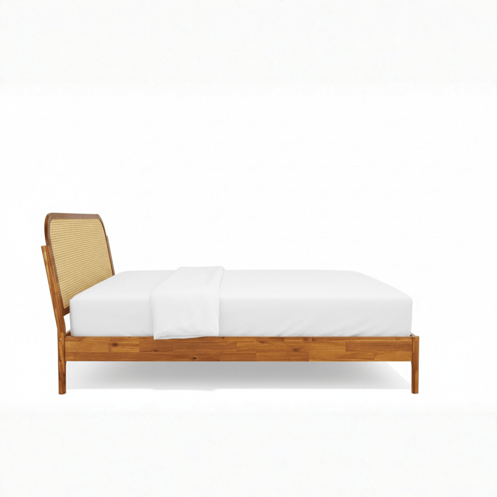 Side profile of teak wood cane bed with sleigh headboard on white background