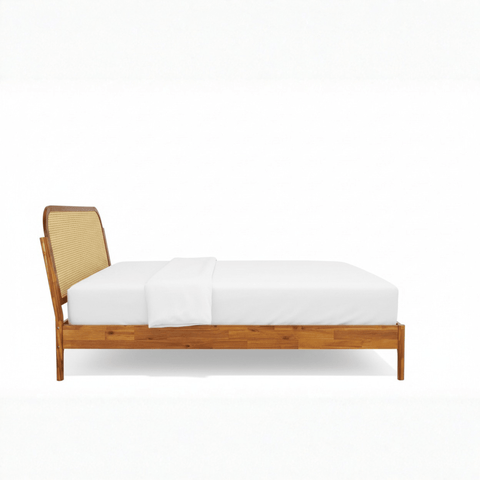 Side profile of teak wood cane bed with sleigh headboard on white background